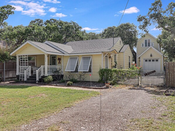 A two-story house with a porch, a garage, and a fenced yard. - Rockport Bungalow 4 Bedroom Home (Rockport)
