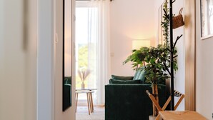 Una sala de estar acogedora con un sofá verde, una mesita de madera y una planta en maceta.
