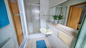 A bathroom with a shower, sink, and toilet.