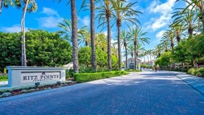 Un sendero pavimentado que conduce a un edificio con un letrero que dice "Ritz Pointe Communities".