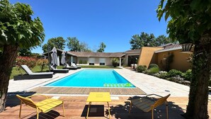 Ein Schwimmbecken mit Liegestühlen und einer Holzterrasse.