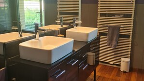Ein modernes Badezimmer mit zwei Waschbecken, einem Spiegel und einem Handtuchhalter.
