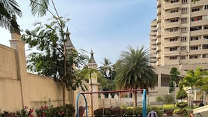 A playground with swings, a slide, and a seesaw. - 2-bedroom apartment in delightful Manipal with AC, WiFi, fitness room (Manipal)