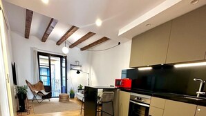 Una cucina moderna con pavimento in legno, un'area pranzo con sedie e un'ampia finestra.