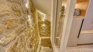 A kitchen with stone walls, a modern design, and a toaster on the countertop. - Central Historic Loft by Architect, Near Louvre (Paris)