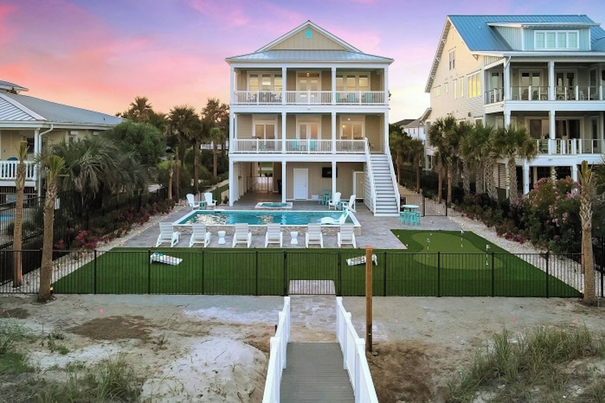 A two-story house with a swimming pool, outdoor seating, and a staircase leading to the upper level.