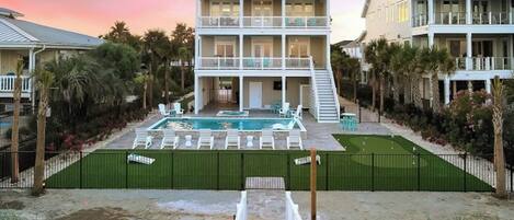 A two-story house with a swimming pool, outdoor seating, and a staircase leading to the upper level.
