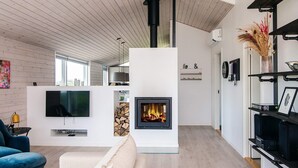 Un salon moderne avec une cheminée, un téléviseur et un canapé.
