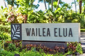 Un panneau portant l’inscription « WAILEA ELUA », entouré de verdure.