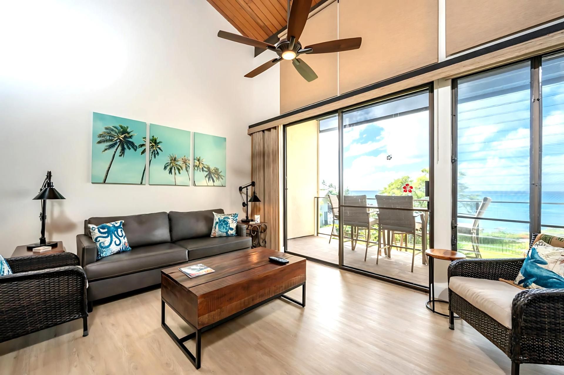 A modern living room with a sofa, coffee table, and wicker chairs.