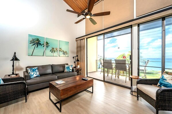 A modern living room with a sofa, coffee table, and wicker chairs.