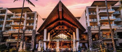 A hotel with a central atrium, multiple balconies, and a landscaped garden.