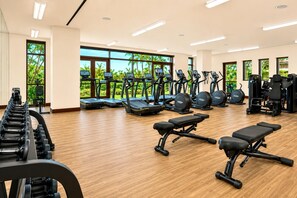 Ein Fitnessstudio mit Laufbändern, Crosstrainern und Gewichten.