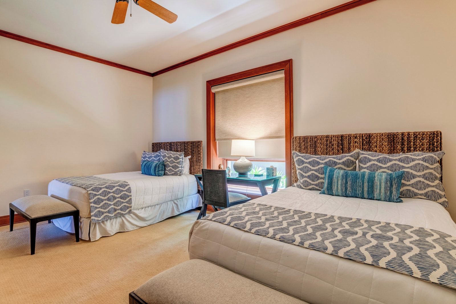 Une chambre d’hôtel avec deux lits, un bureau et une chaise.