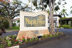 Un letrero para Napili Point Resort, con base de piedra y placa de mármol.