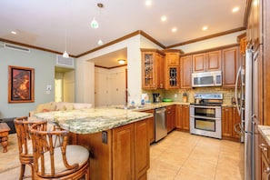 Elegant kitchen with granite countertops, stainless appliances, and warm cabinetry.    KGV-16P3 - Kapalua Golf | Golf View 3 BR, Sleeps 6 | Car Incl. w/ 6+ Nights | KGV ML-1177 by KBM (Lahaina)
