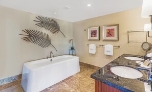 A bathroom with a bathtub, two sinks, a vanity, and decorative wall art. - Honua Kai | Ocean View 5 BR, Sleeps 14 | Car Incl. w/ 6+ Nights | HKH ML-1235 by KBM (Lahaina)