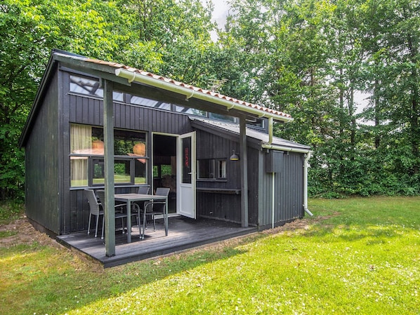 A modern house with a patio, a dining area, and a door leading to the interior. - 4 Person Holiday Home in Hampen (Hampen)