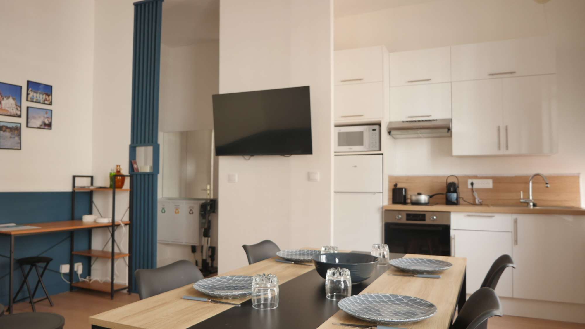 Een moderne keuken met witte kasten, een magnetron en een koffiezetapparaat.