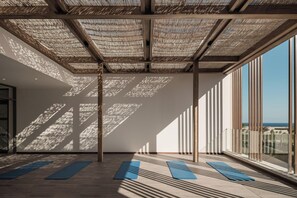 A spacious room with a high ceiling, large windows, and yoga mats on the floor. - JAZ Elite Riviera (Marsa Alam)