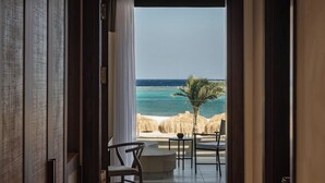 Een gang die uitkomt op een balkon met uitzicht op zee en strand.
