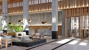 A spacious lobby with high ceilings, large pillars, a seating area with sofas and tables, and a water feature. - JAZ Elite Riviera (Marsa Alam)