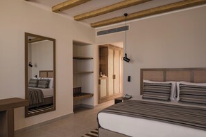 A bedroom with a bed, a wardrobe, a mirror, and a hanging light fixture.