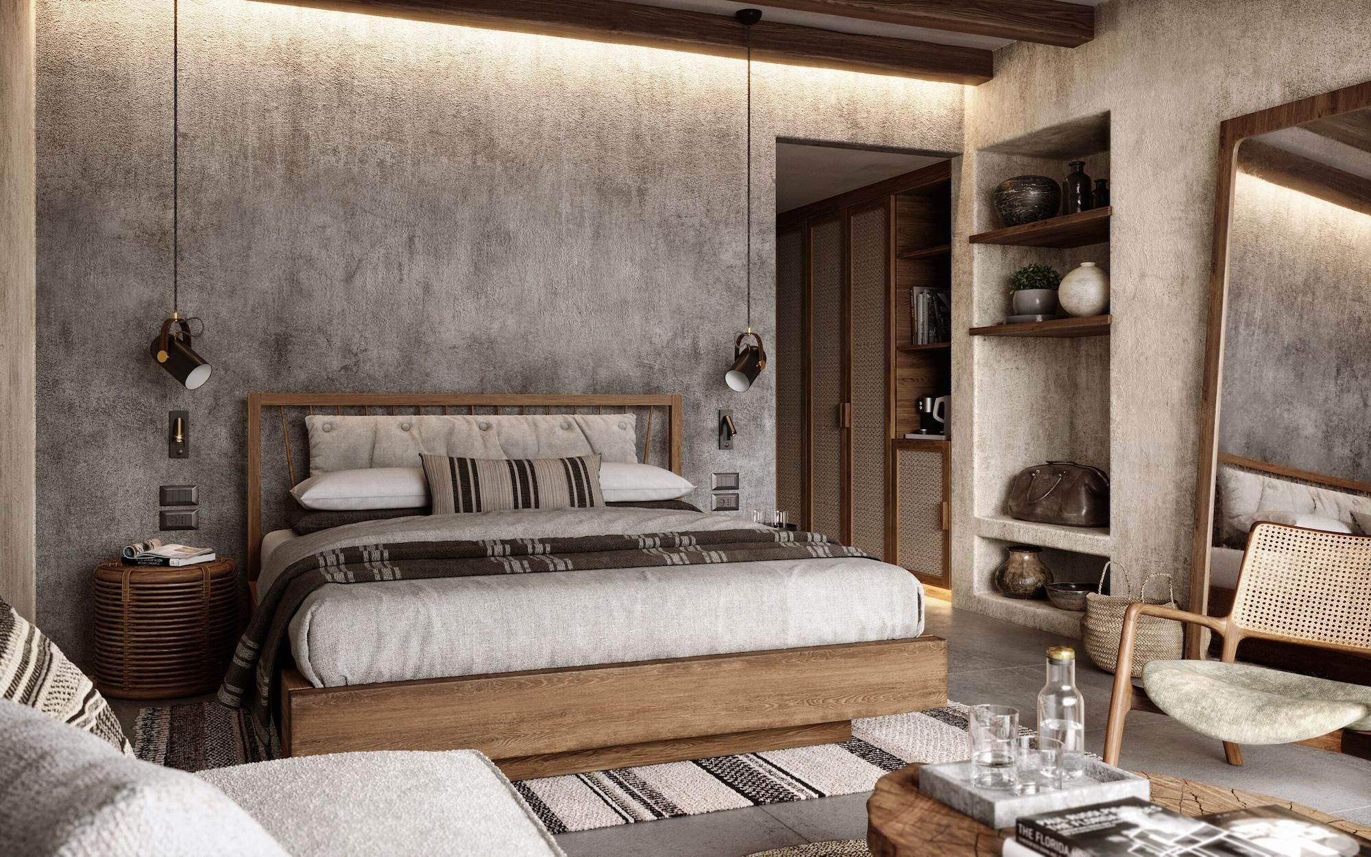 A bedroom with a large bed, wooden headboard, bedside tables, a reading chair, a bookshelf, and a mirror.