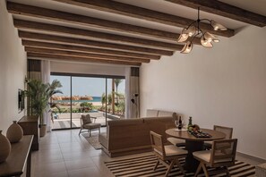 A modern room with a view of the beach, a dining area, and a sofa. - JAZ Elite Riviera (Marsa Alam)