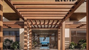 A covered outdoor area with wooden beams and a view of a pool.