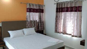 A neatly made bed with white linens, a wooden headboard, and two bedside tables with lamps.