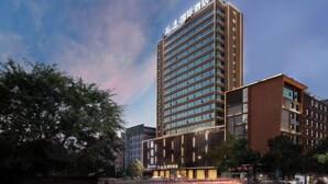 Un moderno edificio de hotel con un letrero llamativo en la parte superior.