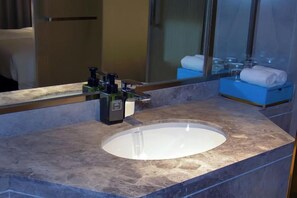 A bathroom with a marble sink, a mirror, and a towel rack. - Haiyi International Hotel Huaihua (Near Huaihua Railway Station, Bubugao Plaza) (Huaihua)