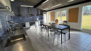 A modern kitchen with a large island, stainless steel appliances, and a view of the outdoors. - 4 Star Holiday Home in Hampen (Hampen)