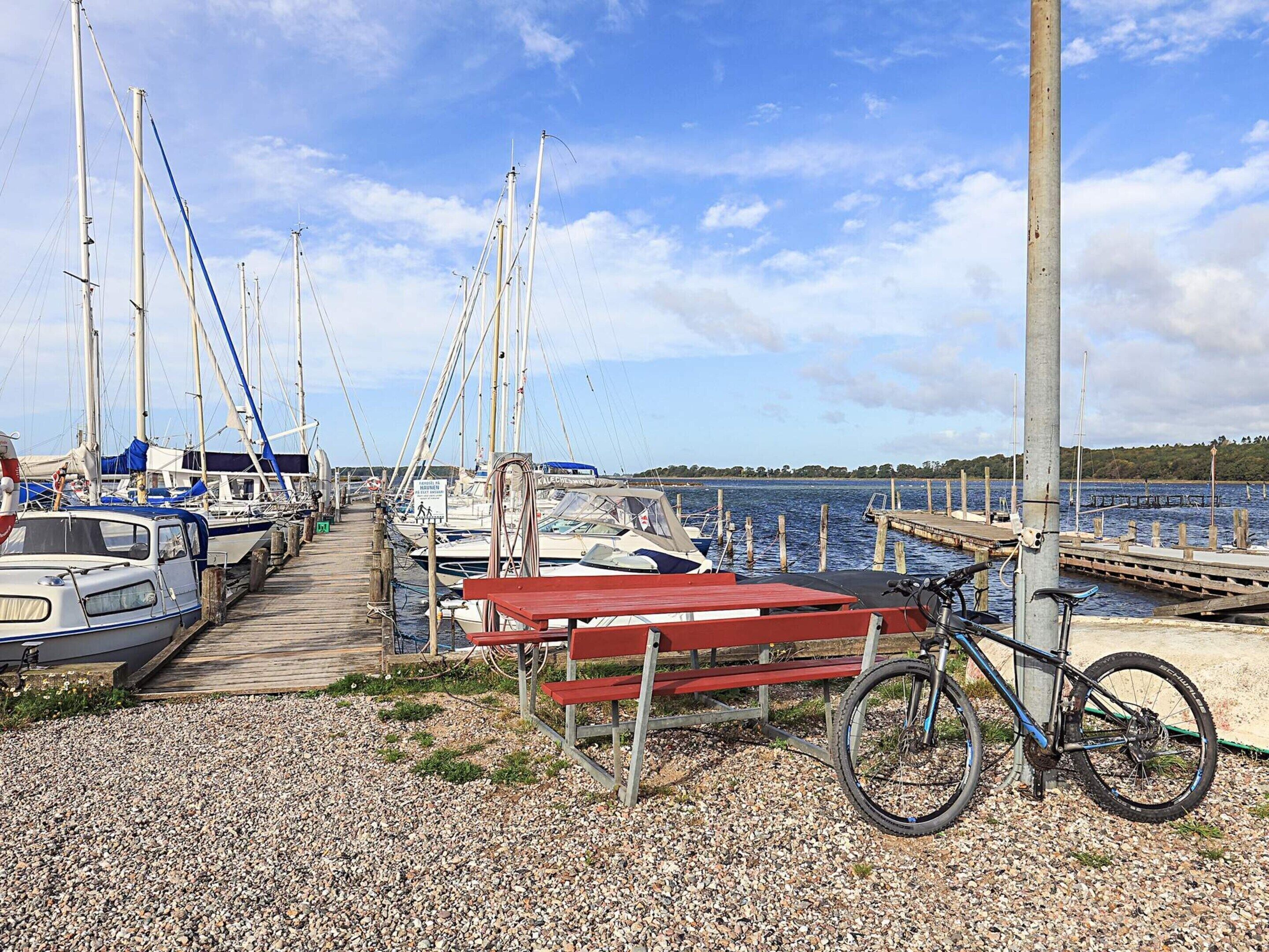 Un port de plaisance avec des bateaux amarrés, une passerelle en bois et un vélo.