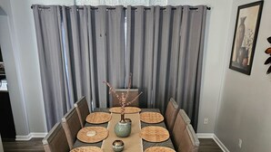 A dining table with woven placemats, a vase with dried flowers, and a lamp above. - Spacious 5-bedroom house in Charming Mesa with Sparkling Heated Pool (Mesa)