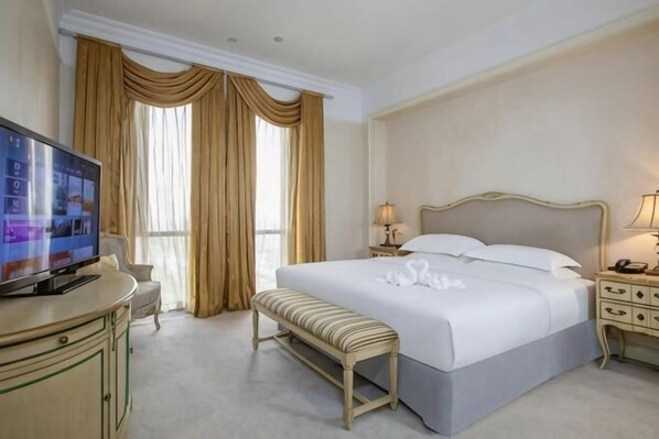 A hotel room with a bed, bedside tables, a TV, a bench, and curtains. - Jiaxing Haining Weijing Wyndham Hotel (Haining)