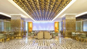 A spacious lobby with a patterned floor, a central seating area, and decorative wall panels. - Jiaxing Haining Weijing Wyndham Hotel (Haining)