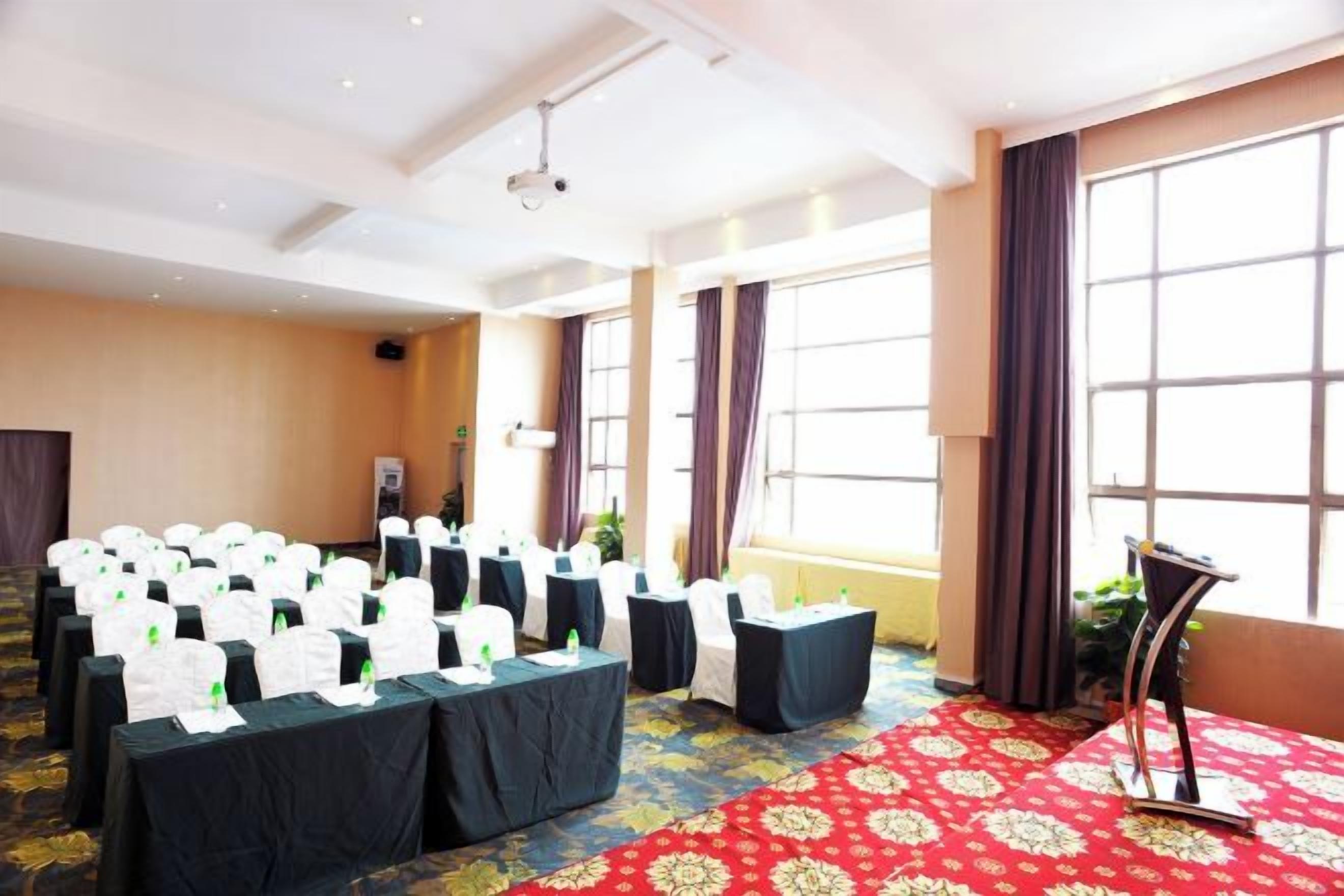 A conference room with rows of tables, a projector, and large windows.