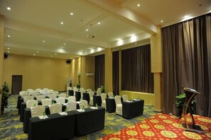 A conference room with rows of chairs, a podium, and a carpeted floor. - Langquan Bay Hotel (Guangzhou South Railway Station) (Guangzhou)