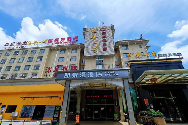 Un hôtel avec une enseigne bien visible, une entrée abritée et un ciel dégagé.