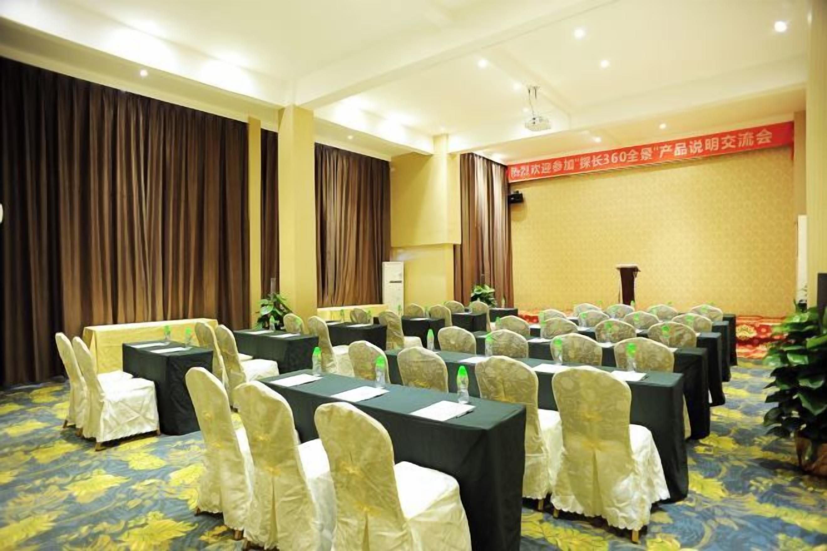 A conference room with tables and chairs, a podium, and a banner on the wall.