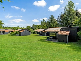 Um camping com várias cabanas, cada uma com entrada independente e área de estar coberta ao ar livre.