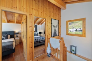 Una cabaña de madera con un dormitorio que incluye una cama, mesitas de noche y una decoración de gnomo.