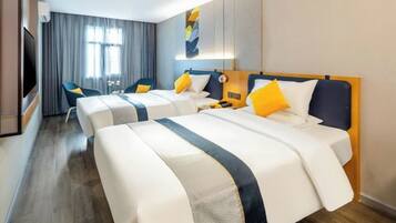 A hotel room with two beds, a TV, a desk, and a chair.