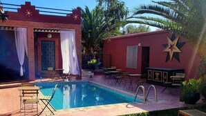 A pool area with a red building, a star decoration, and outdoor seating.