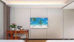A hotel room with two beds, a desk with a plant, a painting of a beach, and a window with curtains. - Yiting Four Seasons Hotel (Shanghai Lujiazui Pudian Road Subway Station) (Shanghai)