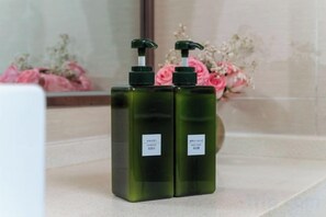 Two dark green bottles with pumps on a countertop. - Yiting Four Seasons Hotel (Shanghai Lujiazui Pudian Road Subway Station) (Shanghai)