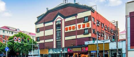 A multi-story building with commercial spaces on the ground floor, including a restaurant and shops.