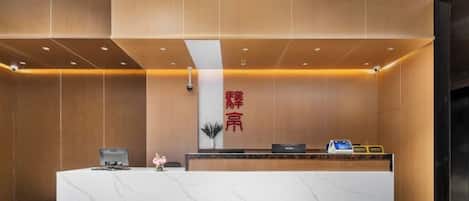 A reception desk with a marble top and a vertical sign with Chinese characters.